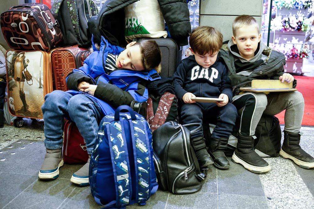 09 March 2022, Poland, Krakow: Ukrainian refugee boys rest on their luggage after arriving at the main train station in Krakow. Millions of Ukrainians fled from their homeland while the Russian invasion enters its second week. Photo: Dominika Zarzycka/SOPA Images via ZUMA Press Wire/dpa.
