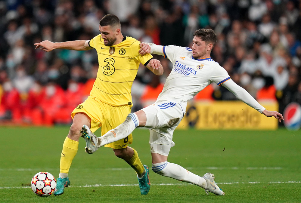 12 April 2022, Spain, Madrid: Chelsea's Mateo Kovacic (L) challenged by Real Madrid's Federico Valverde during the UEFA Champions League Quarter-final second leg soccer match between Real Madrid CF and Chelsea FC at Santiago Bernabeu Stadium. Photo: Nick Potts/PA Wire/dpa.
